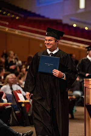 Students graduate and walk to recieve their diplomas during convocation in the College of Business and Communications.