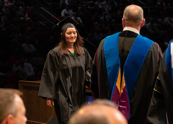 Students graduate and walk to receive their diplomas during convocation in the College of Physical Sciences and Engineering.