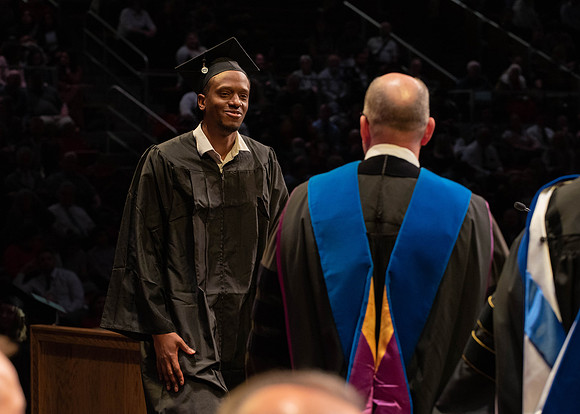 Students graduate and walk to receive their diplomas during convocation in the College of Physical Sciences and Engineering.