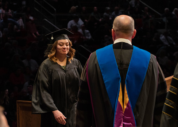 Students graduate and walk to receive their diplomas during convocation in the College of Physical Sciences and Engineering.