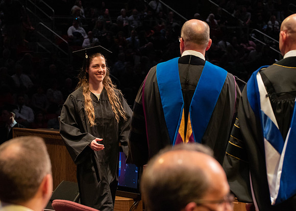 Students graduate and walk to receive their diplomas during convocation in the College of Physical Sciences and Engineering.