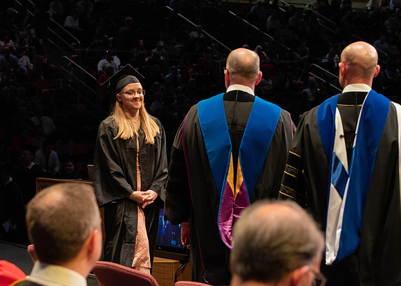 Students graduate and walk to receive their diplomas during convocation in the College of Physical Sciences and Engineering.