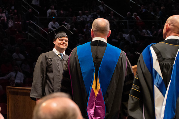 Students graduate and walk to receive their diplomas during convocation in the College of Physical Sciences and Engineering.