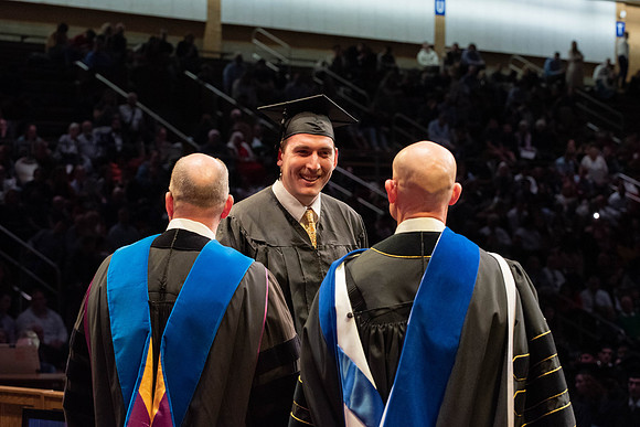 Students graduate and walk to receive their diplomas during convocation in the College of Physical Sciences and Engineering.