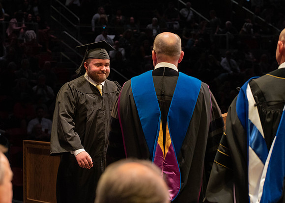 Students graduate and walk to receive their diplomas during convocation in the College of Physical Sciences and Engineering.