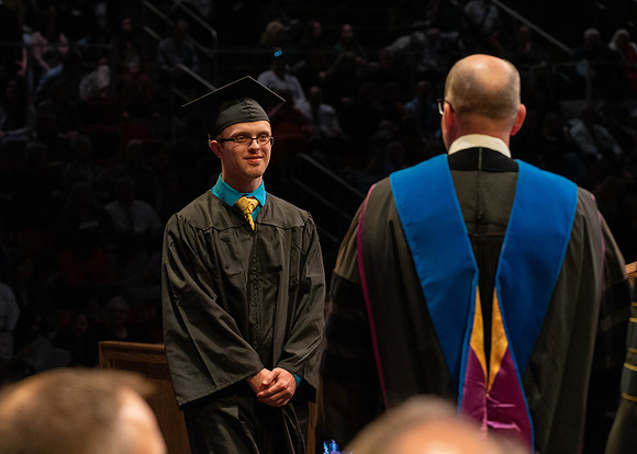 Students graduate and walk to receive their diplomas during convocation in the College of Physical Sciences and Engineering.