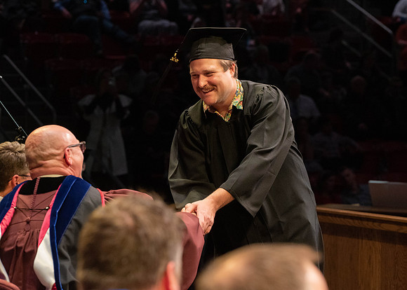 Students graduate and walk to receive their diplomas during convocation in the College of Physical Sciences and Engineering.