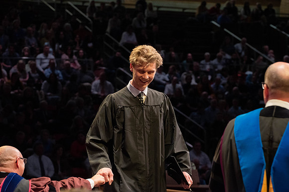 Students graduate and walk to receive their diplomas during convocation in the College of Physical Sciences and Engineering.