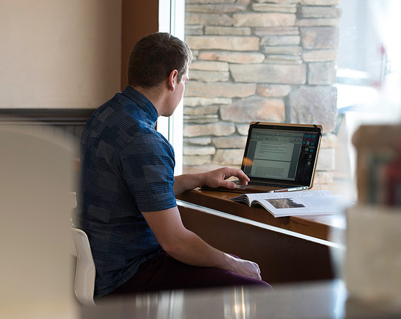 Blake Jensen studies for an Online class at the Cocoa Bean Cafe in Rexburg, ID.