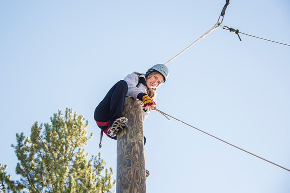 Student Haley Beautler climbs up the Power Pole at iGrow.