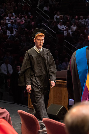 Students graduate and walk to receive their diplomas during convocation in the College of Physical Sciences and Engineering.