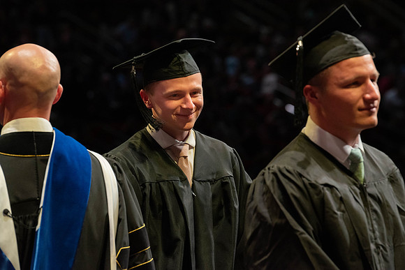 Students graduate and walk to receive their diplomas during convocation in the College of Physical Sciences and Engineering.
