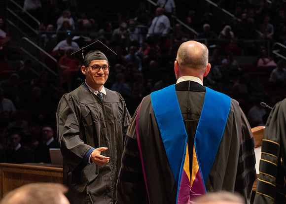 Students graduate and walk to receive their diplomas during convocation in the College of Physical Sciences and Engineering.