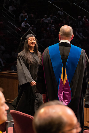 Students graduate and walk to receive their diplomas during convocation in the College of Physical Sciences and Engineering.