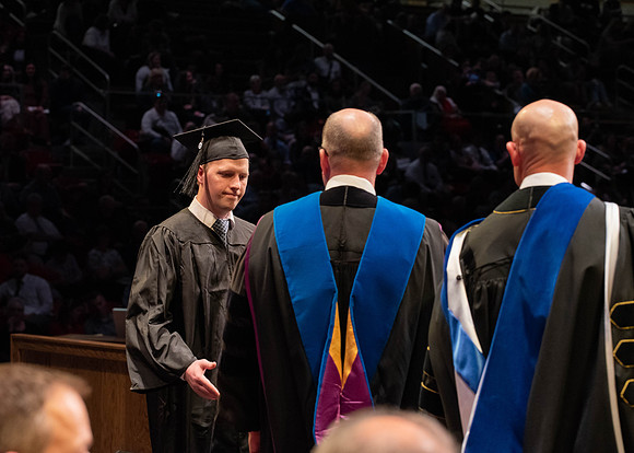 Students graduate and walk to receive their diplomas during convocation in the College of Physical Sciences and Engineering.