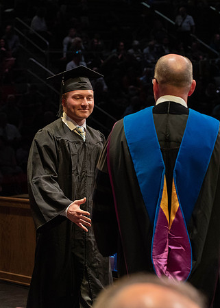 Students graduate and walk to receive their diplomas during convocation in the College of Physical Sciences and Engineering.