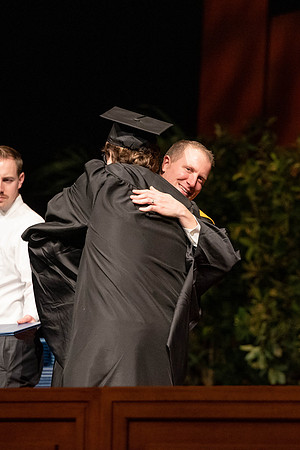 Students graduate and walk to recieve their diplomas during convocation in the College of Business and Communications.