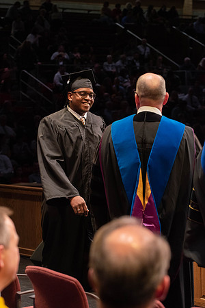 Students graduate and walk to receive their diplomas during convocation in the College of Physical Sciences and Engineering.