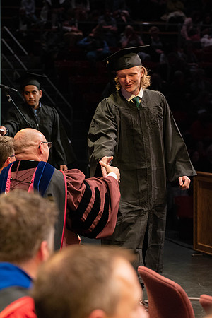 Students graduate and walk to receive their diplomas during convocation in the College of Physical Sciences and Engineering.