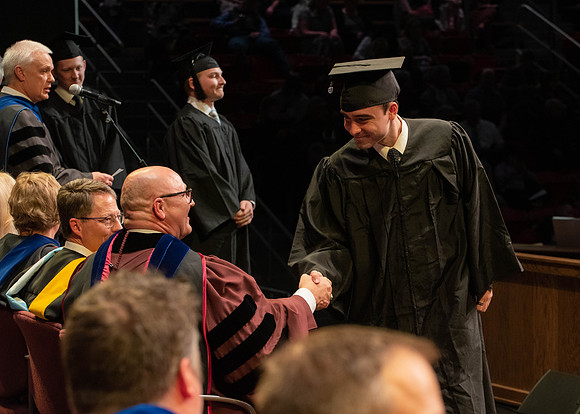 Students graduate and walk to receive their diplomas during convocation in the College of Physical Sciences and Engineering.