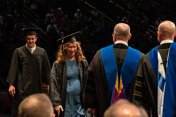 Students graduate and walk to receive their diplomas during convocation in the College of Physical Sciences and Engineering.
