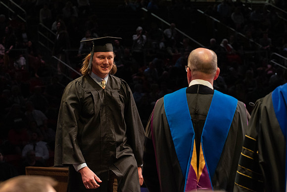 Students graduate and walk to receive their diplomas during convocation in the College of Physical Sciences and Engineering.