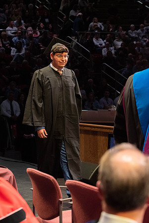 Students graduate and walk to receive their diplomas during convocation in the College of Physical Sciences and Engineering.