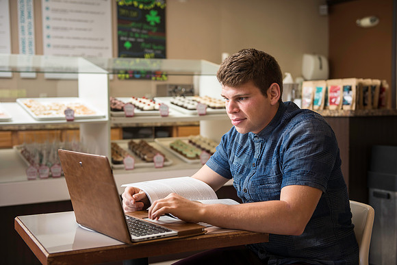 Blake Jensen studies for an Online class at the Cocoa Bean Cafe in Rexburg, ID.