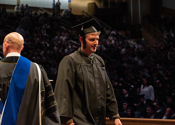 Students graduate and walk to receive their diplomas during convocation in the College of Physical Sciences and Engineering.