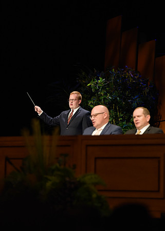 Elder Kyle S. McKay address students of BYU-Idaho in the I-Center. Other students and Henry J. Eyring assist in the Devotional.