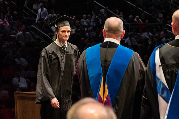 Students graduate and walk to receive their diplomas during convocation in the College of Physical Sciences and Engineering.