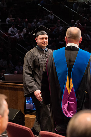 Students graduate and walk to receive their diplomas during convocation in the College of Physical Sciences and Engineering.