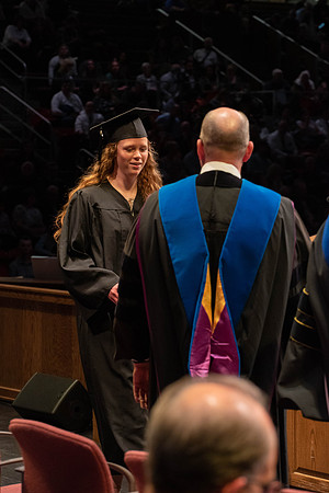 Students graduate and walk to receive their diplomas during convocation in the College of Physical Sciences and Engineering.