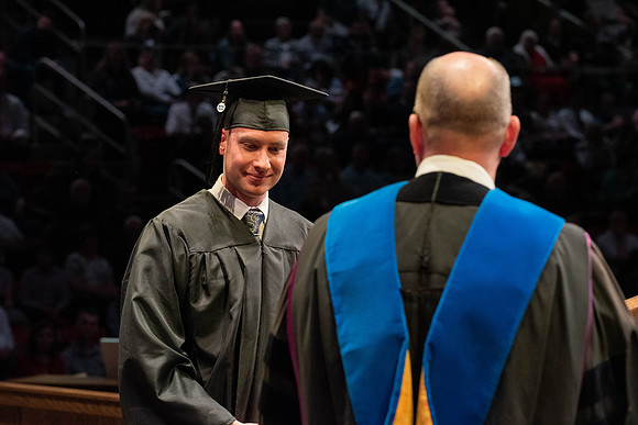 Students graduate and walk to receive their diplomas during convocation in the College of Physical Sciences and Engineering.