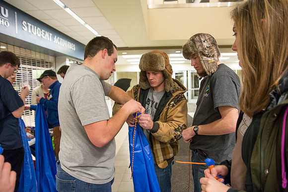 Students learn to make hammocks out of parachute material.