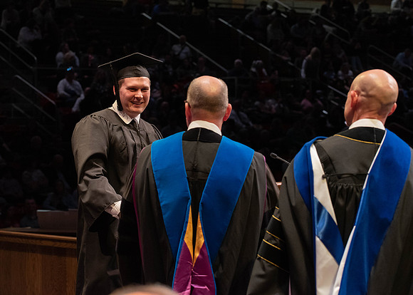 Students graduate and walk to receive their diplomas during convocation in the College of Physical Sciences and Engineering.