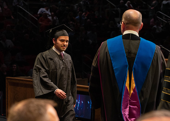 Students graduate and walk to receive their diplomas during convocation in the College of Physical Sciences and Engineering.