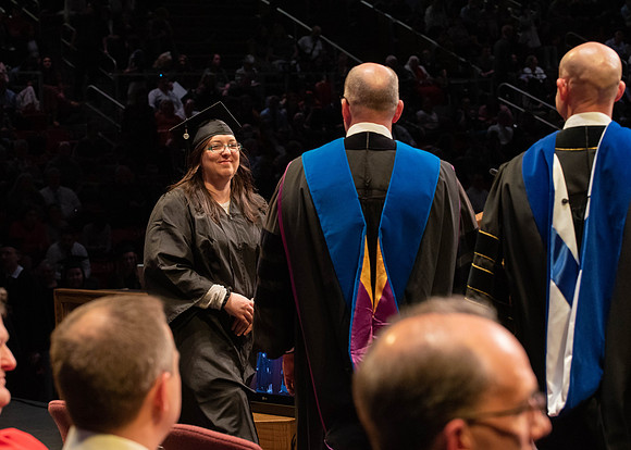 Students graduate and walk to receive their diplomas during convocation in the College of Physical Sciences and Engineering.