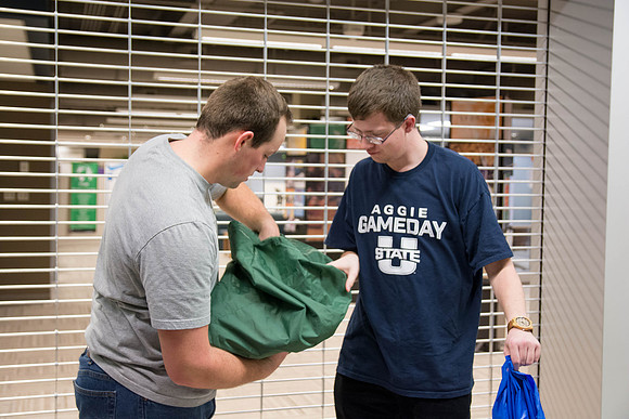 Students learn to make hammocks out of parachute material.