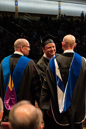 Students graduate and walk to receive their diplomas during convocation in the College of Physical Sciences and Engineering.