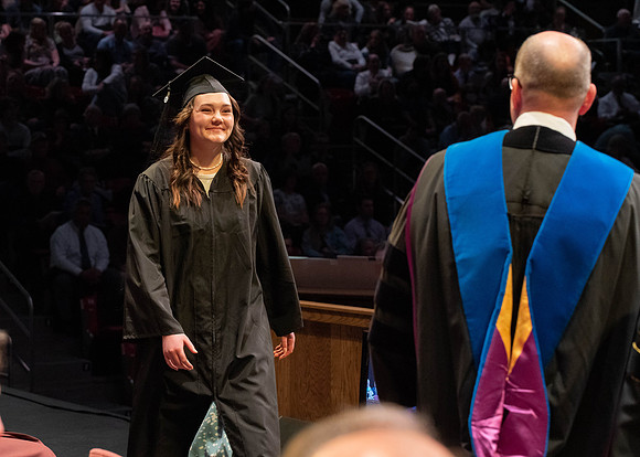 Students graduate and walk to receive their diplomas during convocation in the College of Physical Sciences and Engineering.
