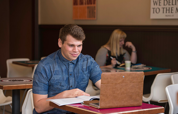 Blake Jensen studies for an Online class at the Cocoa Bean Cafe in Rexburg, ID.