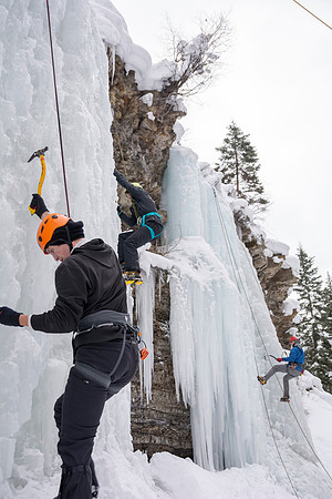 Davin Lybbart with students belaying other students ice climbing.