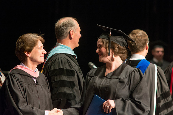 Faculty members hand degrees to and congratualate graduates of the College of Performing and Visual Arts.