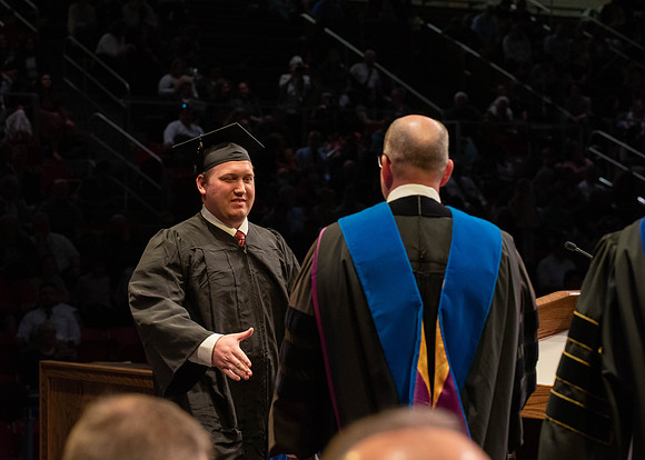 Students graduate and walk to receive their diplomas during convocation in the College of Physical Sciences and Engineering.
