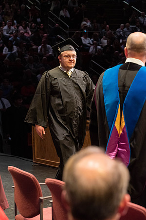 Students graduate and walk to receive their diplomas during convocation in the College of Physical Sciences and Engineering.
