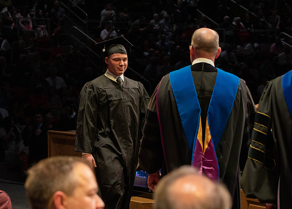 Students graduate and walk to receive their diplomas during convocation in the College of Physical Sciences and Engineering.
