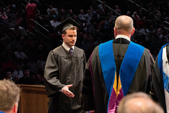 Students graduate and walk to receive their diplomas during convocation in the College of Physical Sciences and Engineering.