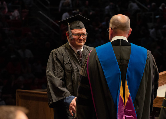 Students graduate and walk to receive their diplomas during convocation in the College of Physical Sciences and Engineering.