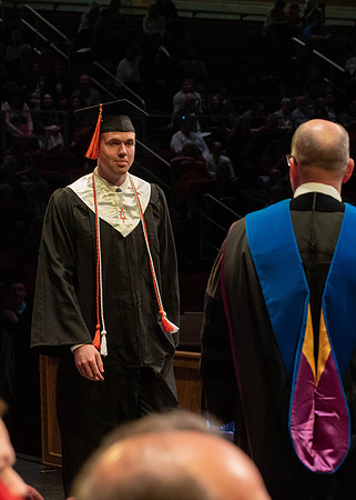 Students graduate and walk to receive their diplomas during convocation in the College of Physical Sciences and Engineering.